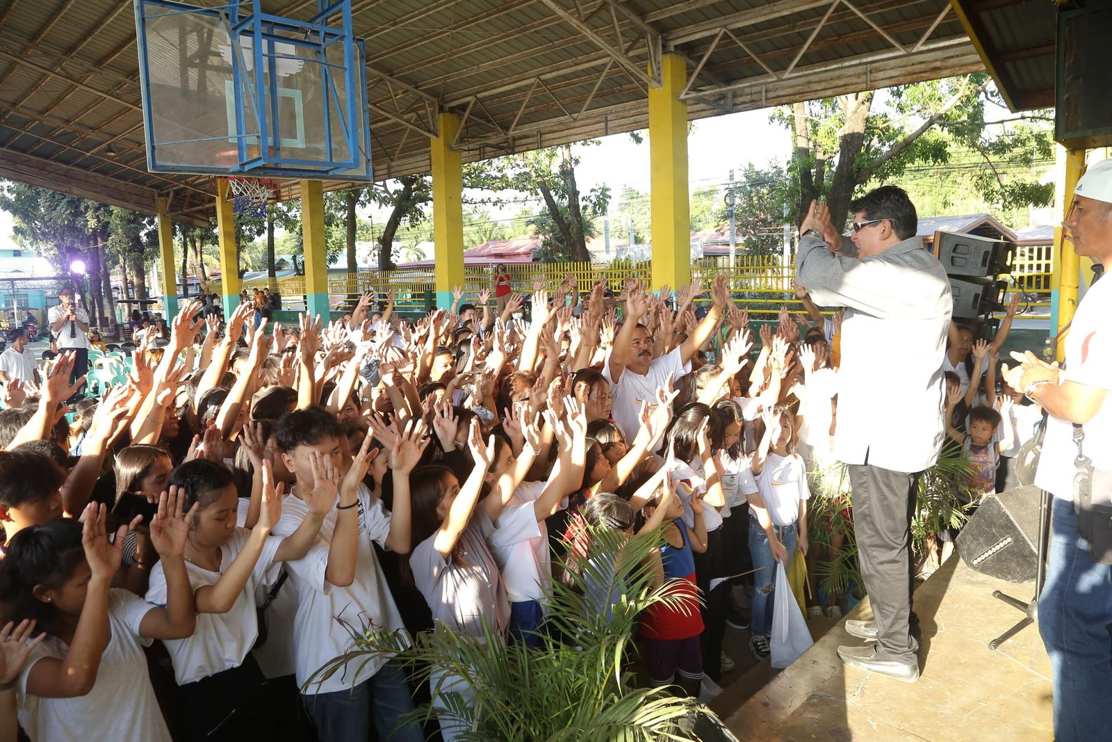 a man standing in front of a group of people raising their hands