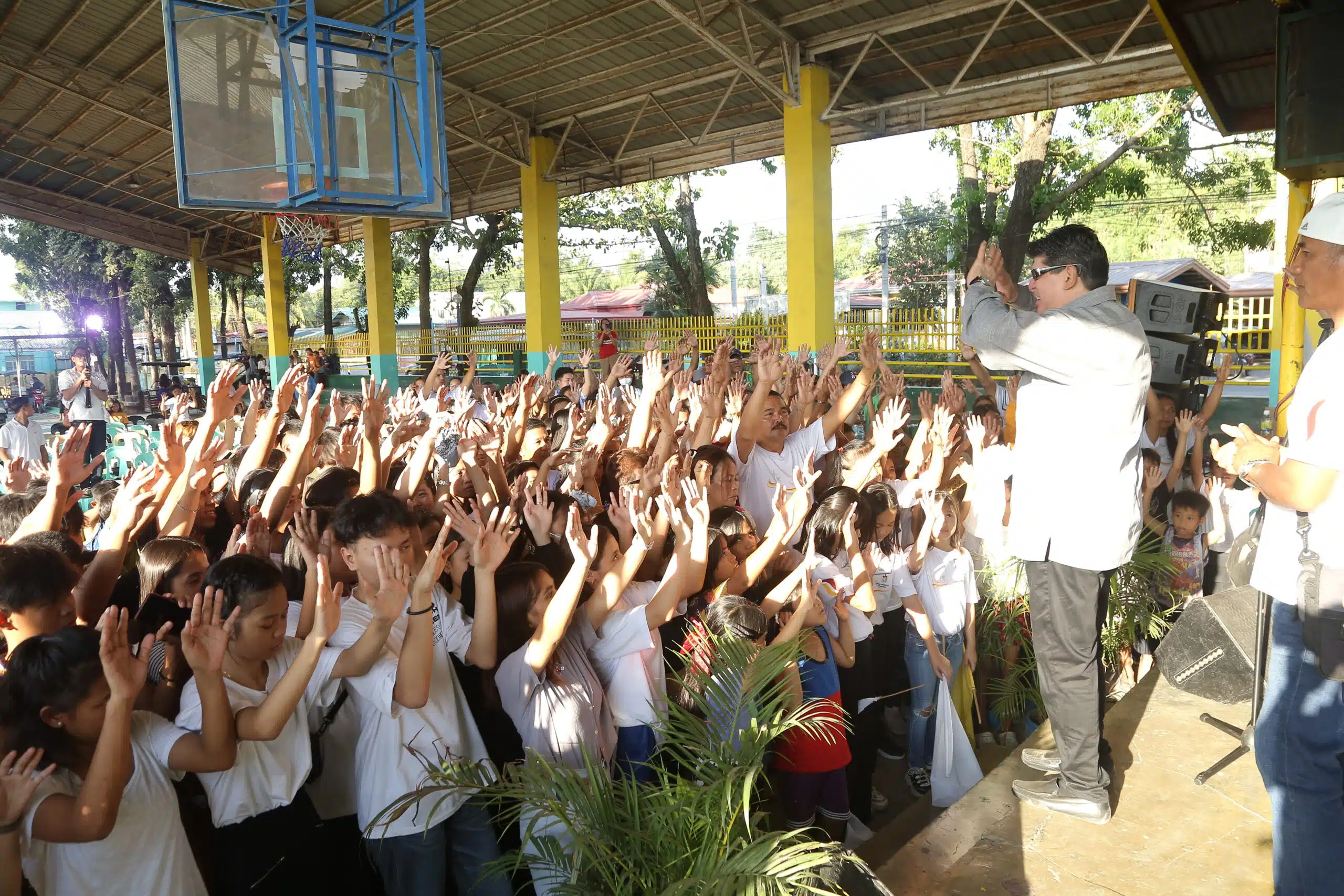 a man standing in front of a group of people raising their hands